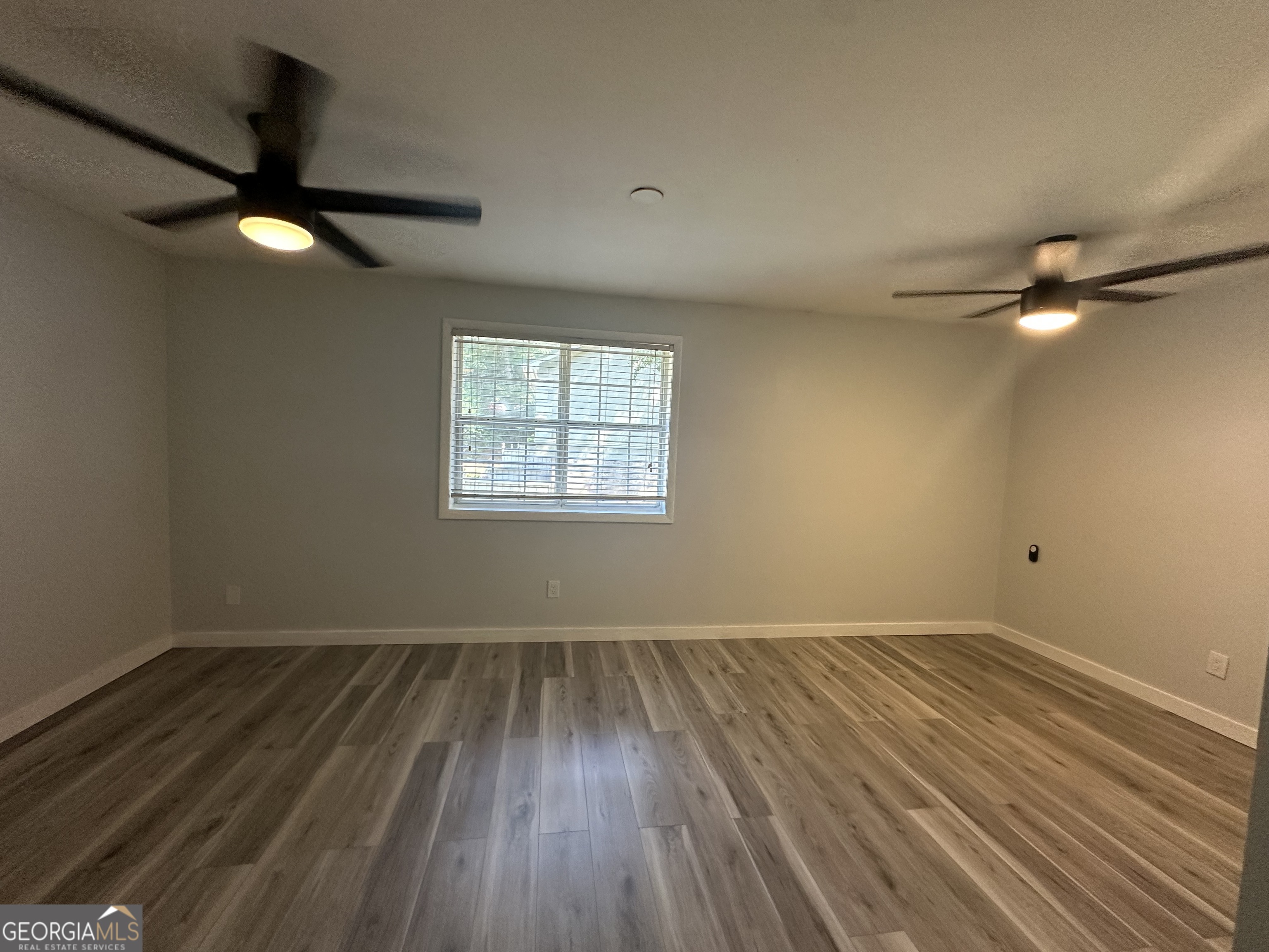 6900 Roswell Road, Unit K8 Sandy Springs, GA 30328 - Photo 20 of 30 an empty room with wooden floor fan and windows