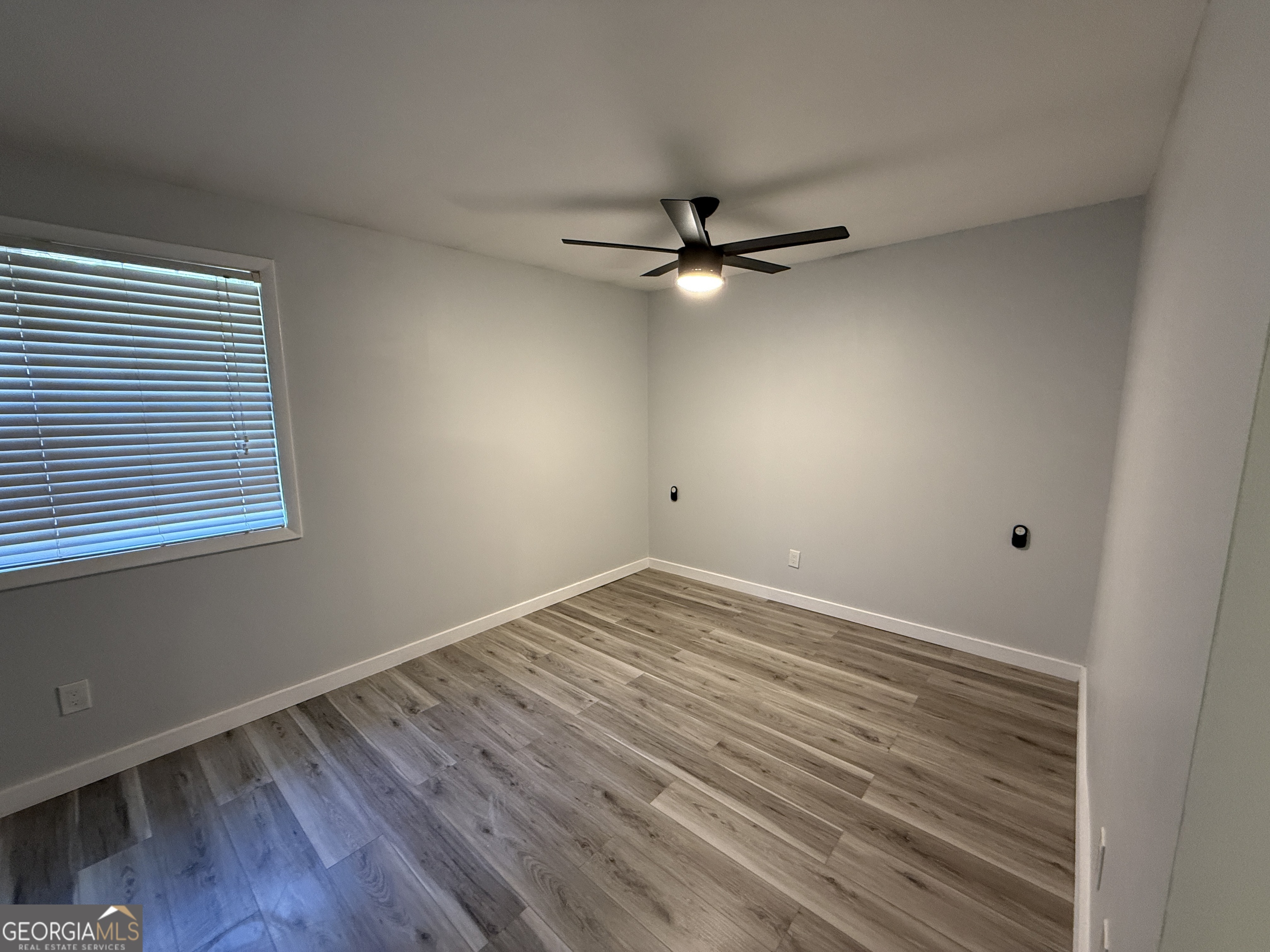 6900 Roswell Road, Unit K8 Sandy Springs, GA 30328 - Photo 21 of 30 an empty room with wooden floor fan and windows