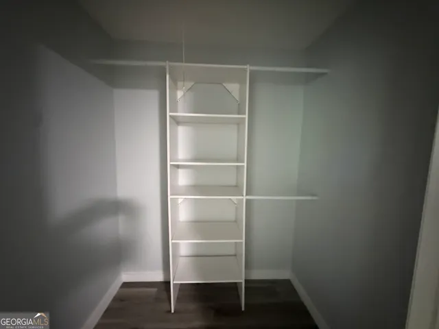 a view of walk in closet with empty racks