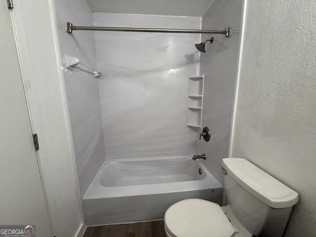 a bathroom with a toilet and a shower