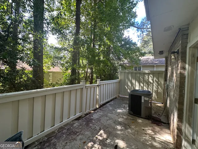 a balcony with wooden floor and outdoor seating
