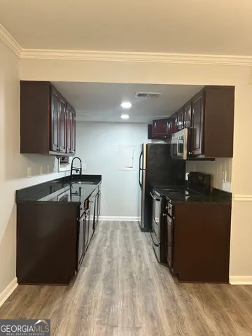 a kitchen with stainless steel appliances granite countertop a refrigerator a stove and a sink