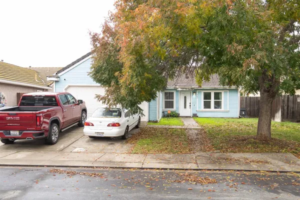 a front view of a house with cars parked