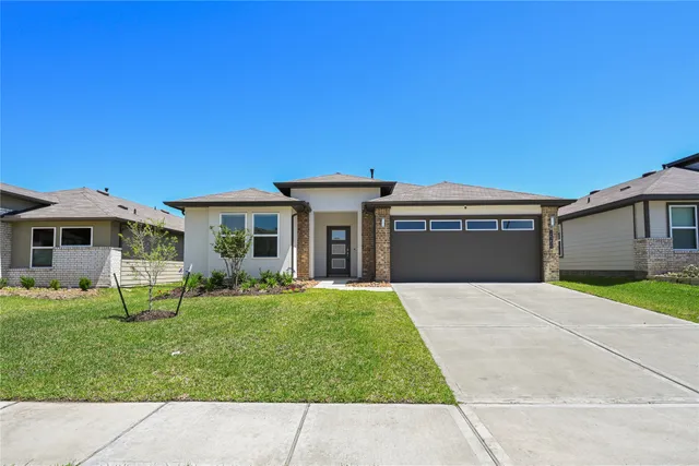 a front view of a house with a garden and yard