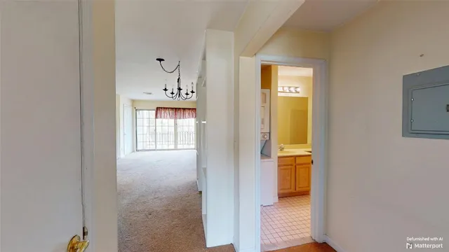 a view of a hallway with wooden floor and a bathroom