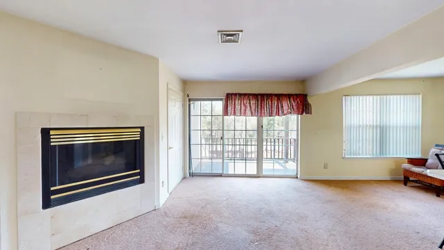 a view of an empty room with a fireplace and a window