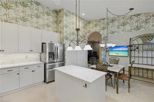a kitchen with stainless steel appliances kitchen island granite countertop a refrigerator and a stove