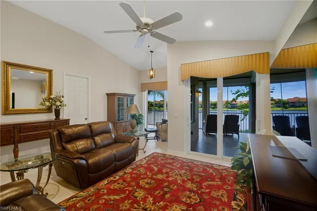 a living room with furniture wooden floor and a large window