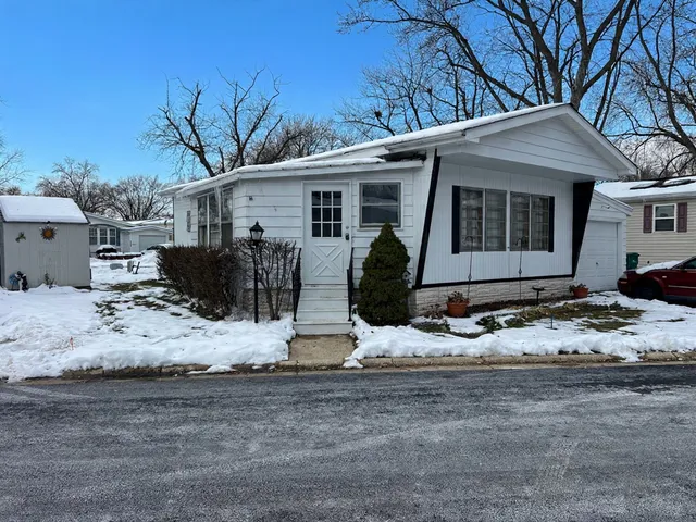 a view of a house with a yard covered in snow