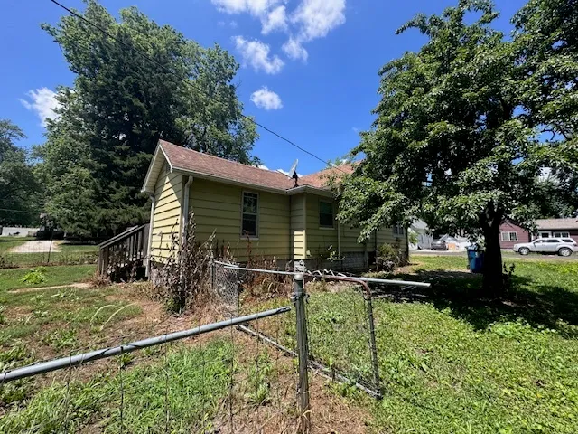 a view of backyard of house with green space