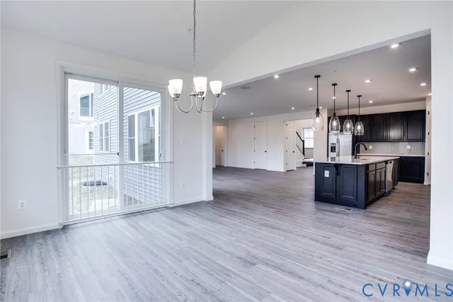 a large kitchen with stainless steel appliances granite countertop a stove top oven a sink dishwasher and wooden floor