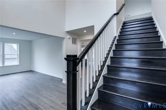 a view of a hallway with wooden floor and staircase