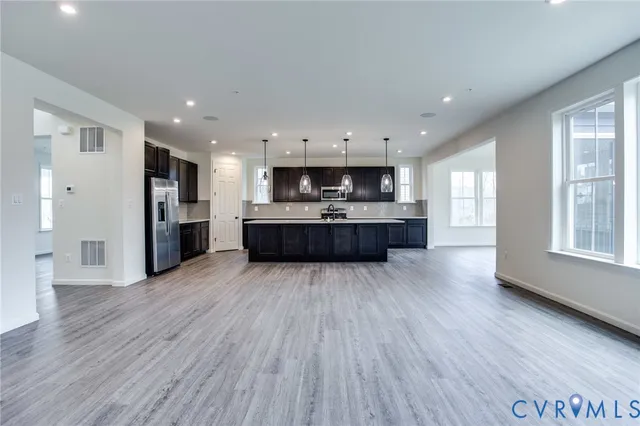 a large kitchen with cabinets wooden floor and stainless steel appliances