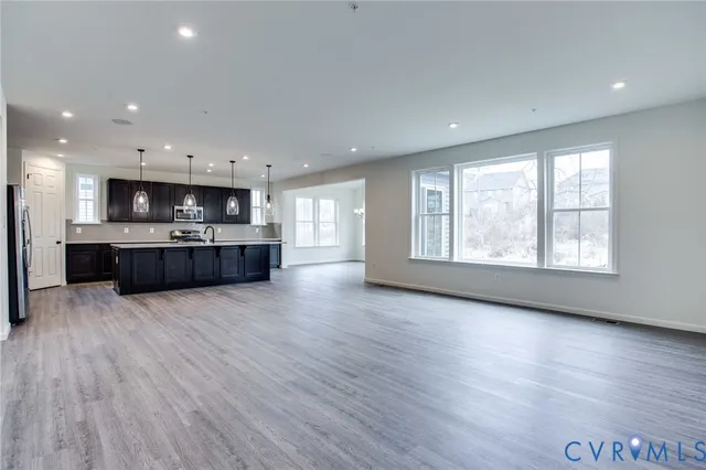 an empty room with wooden floor and large windows