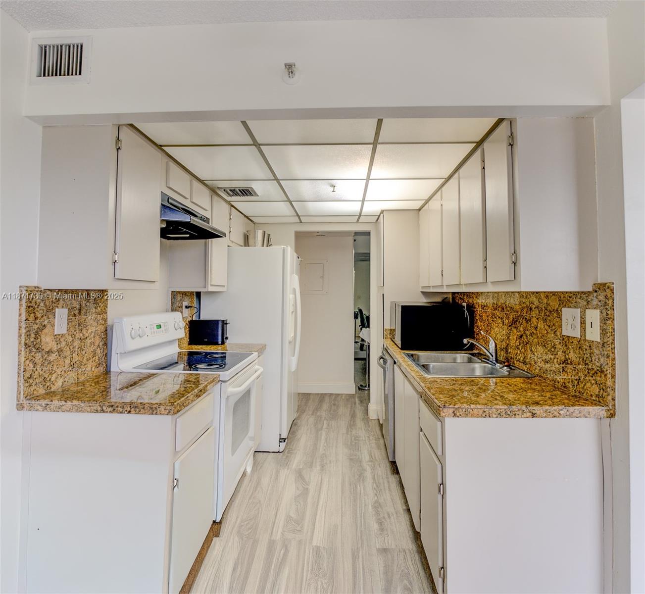 210 174th Street, Unit 312 Sunny Isles Beach, FL 33160 - Photo 12 of 16 a kitchen with stainless steel appliances granite countertop a sink stove and refrigerator