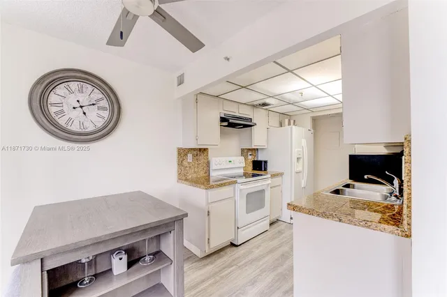 a kitchen with a stove and a clock on the wall