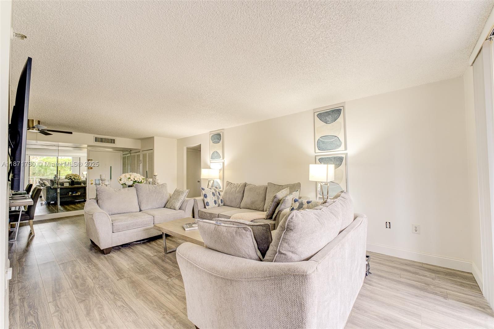 210 174th Street, Unit 312 Sunny Isles Beach, FL 33160 - Photo 10 of 16 a living room with furniture and a wooden floor