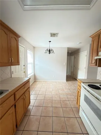 a kitchen with a sink a stove cabinets and a window