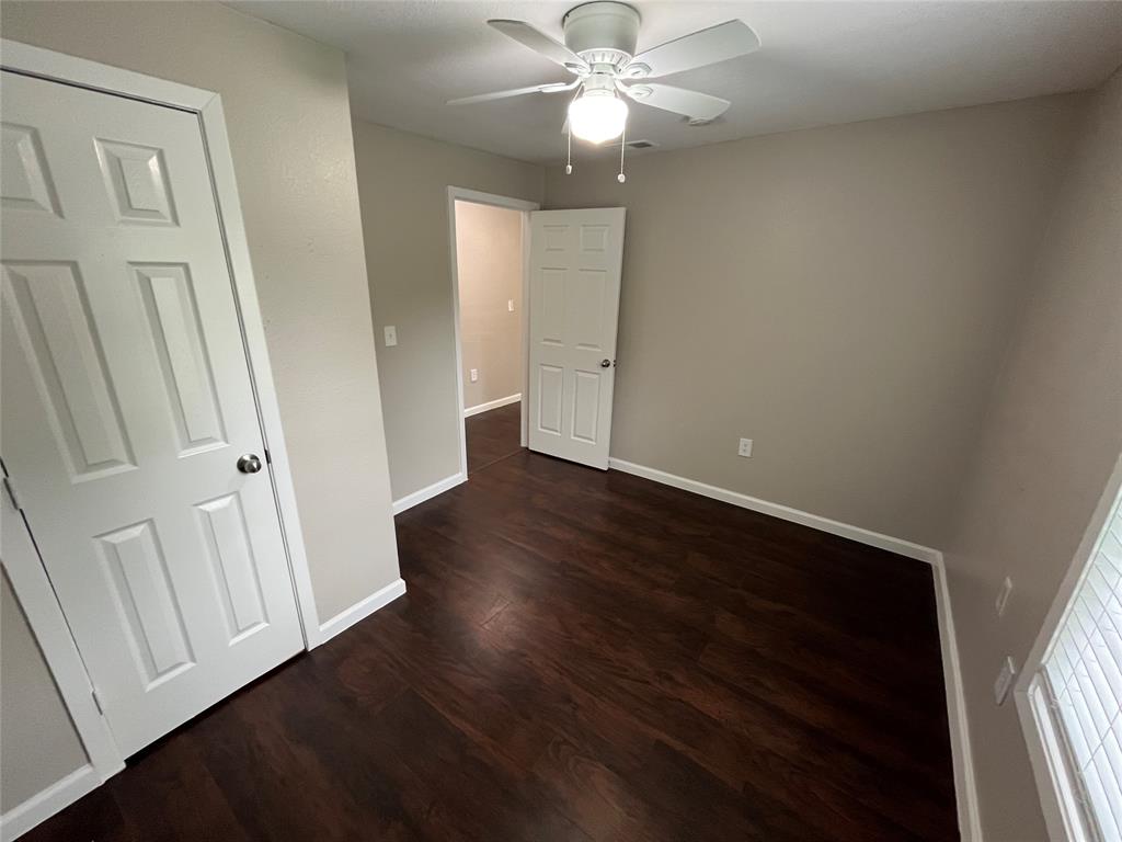 9558 Rylie Crest Drive Dallas, TX 75217 - Photo 10 of 14 Room featuring dark wood-finish flooring, light neutral-toned walls, and a white ceiling fan with integrated lighting