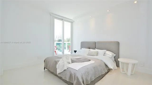 a bedroom with a bed and a large window
