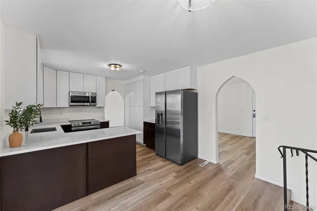 a kitchen with a refrigerator and a stove top oven