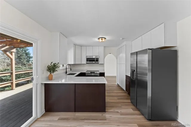 a kitchen with stainless steel appliances granite countertop a refrigerator a sink a stove and cabinets