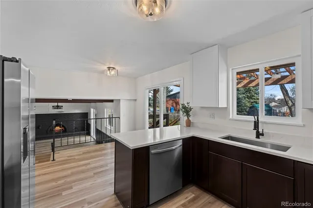 a kitchen with stainless steel appliances a sink cabinets and wooden floor