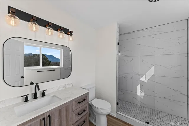 a bathroom with a sink mirror toilet and shower