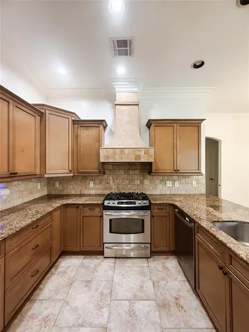 a kitchen with stainless steel appliances granite countertop a stove sink and cabinets