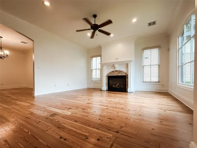 an empty room with fireplace fan and windows
