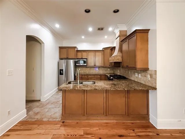 a view of kitchen with stainless steel appliances granite countertop sink stove refrigerator and cabinets