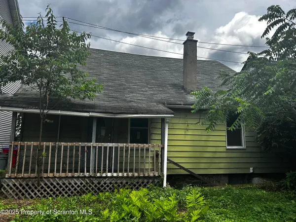 a side view of a house with a small yard