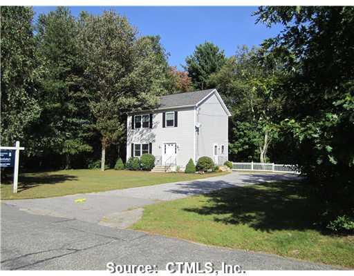 a view of a house with backyard and trees