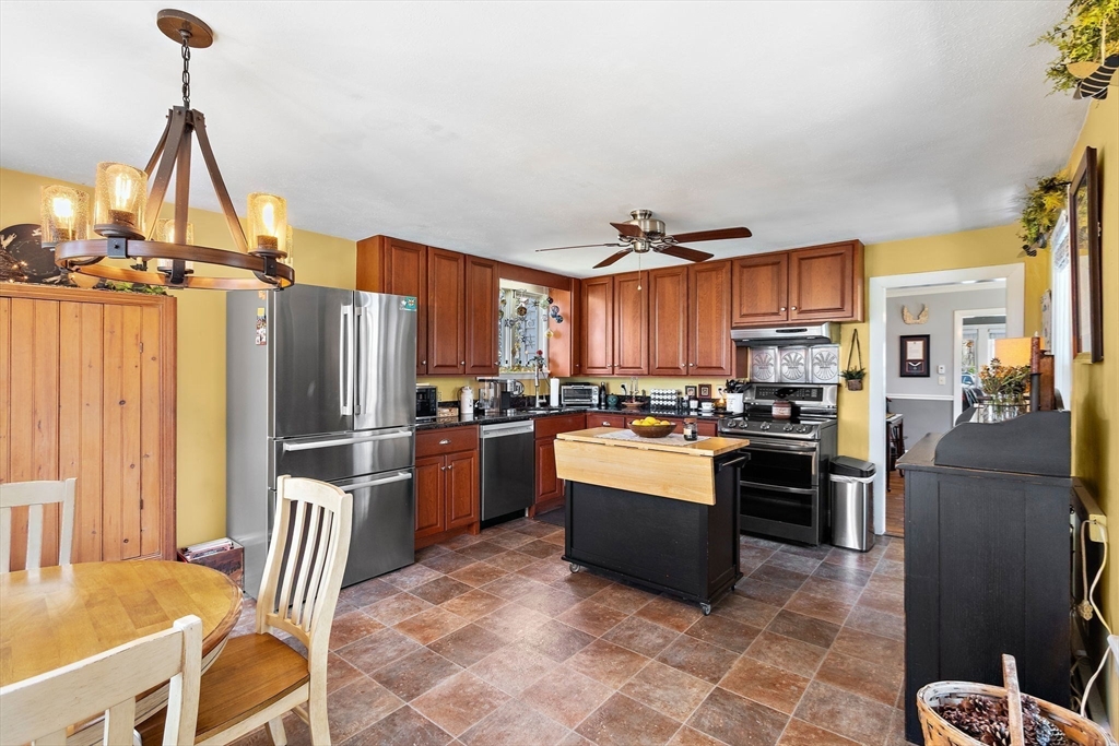 141 Westview Road Lowell, MA 01851 - Photo 6 of 39 a kitchen with stainless steel appliances granite countertop a refrigerator a stove a sink a dining table and chairs