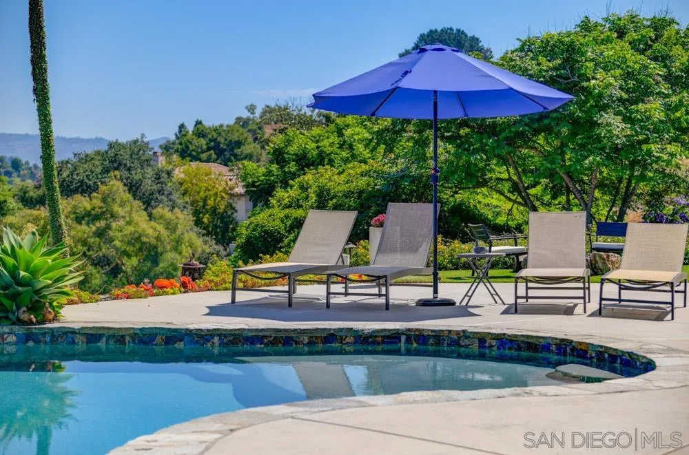 1834 Winterwarm Drive Fallbrook, CA 92028 - Photo 20 of 49 an outdoor sitting area with chairs and table under an umbrella