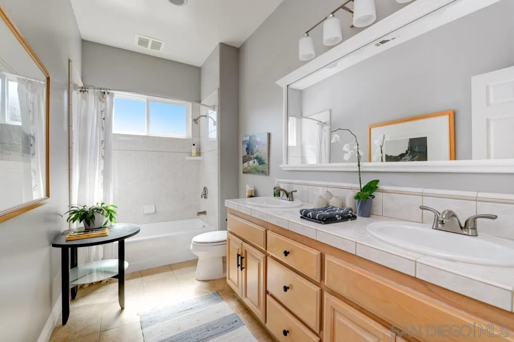 1834 Winterwarm Drive Fallbrook, CA 92028 - Photo 43 of 49 a bathroom with a granite countertop sink a toilet and mirror