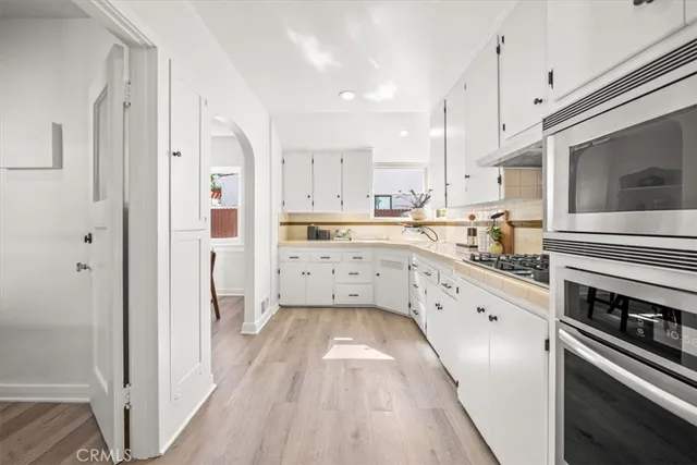 a kitchen with stainless steel appliances kitchen island granite countertop a stove a sink and a refrigerator