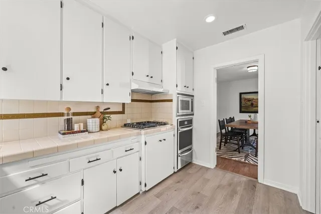 a kitchen with granite countertop white cabinets and white appliances