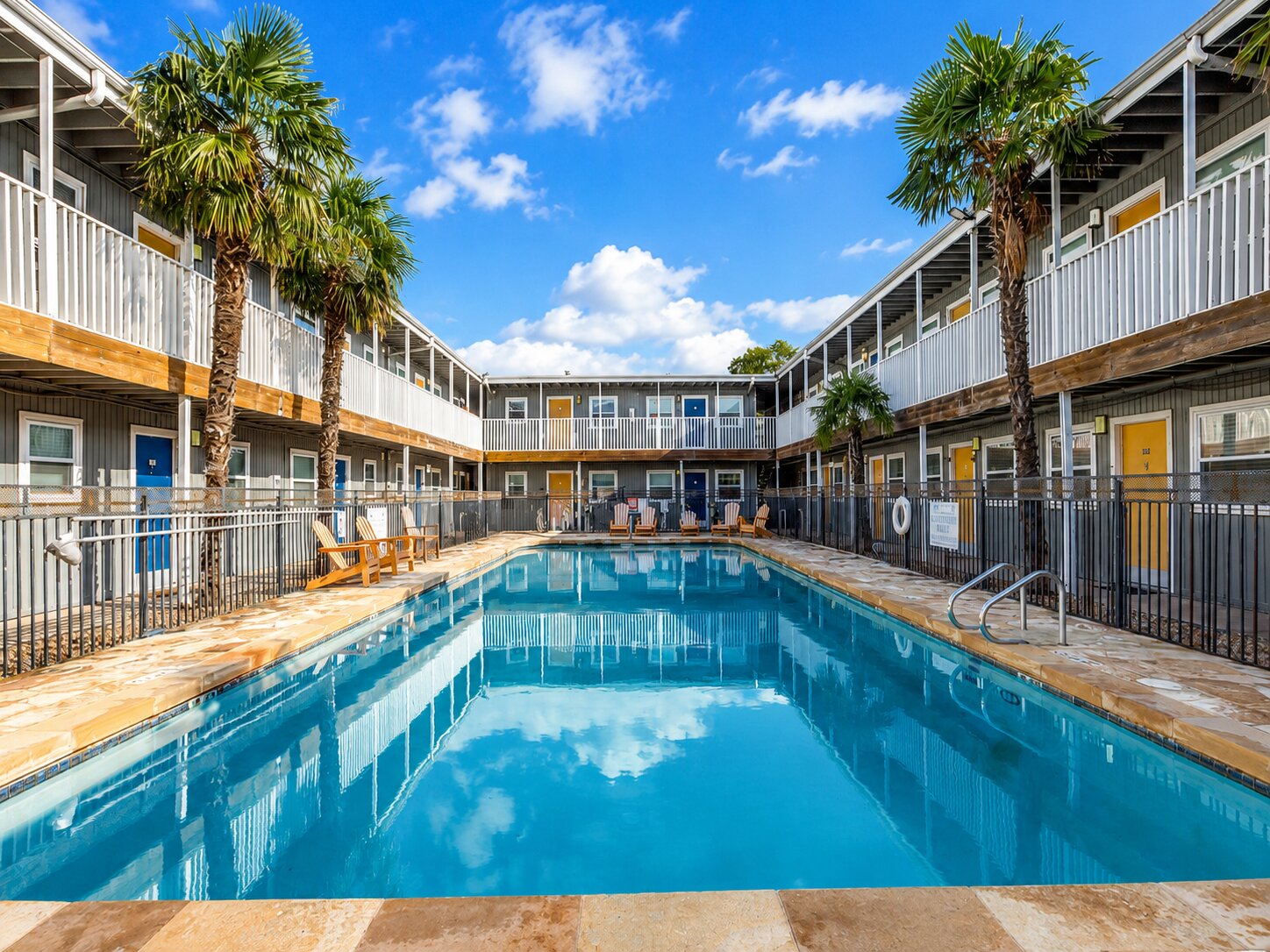 2401 Manor Road, Unit 218 Austin, TX 78722 - Photo 8 of 27 A sparkling pool with surrounding lounge chairs offers a refreshing oasis amidst a multi-level residential complex.