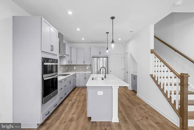a kitchen with kitchen island a sink stainless steel appliances and cabinets