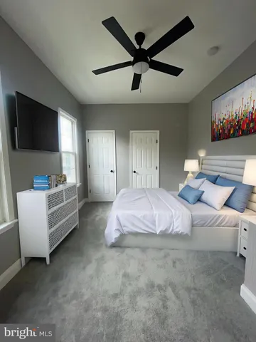 a spacious bedroom with a bed a couch and a flat screen tv