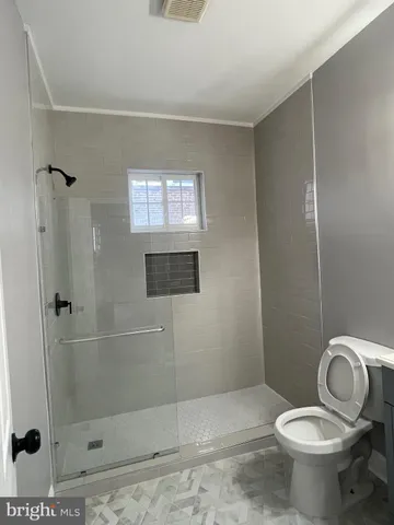 a bathroom with a toilet and a shower