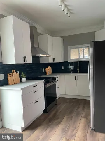 a kitchen with granite countertop a sink a stove and cabinets