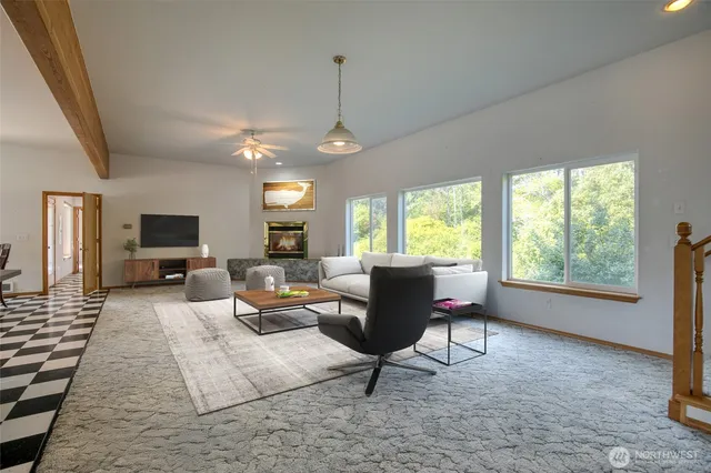a living room with furniture a flat screen tv and a large window
