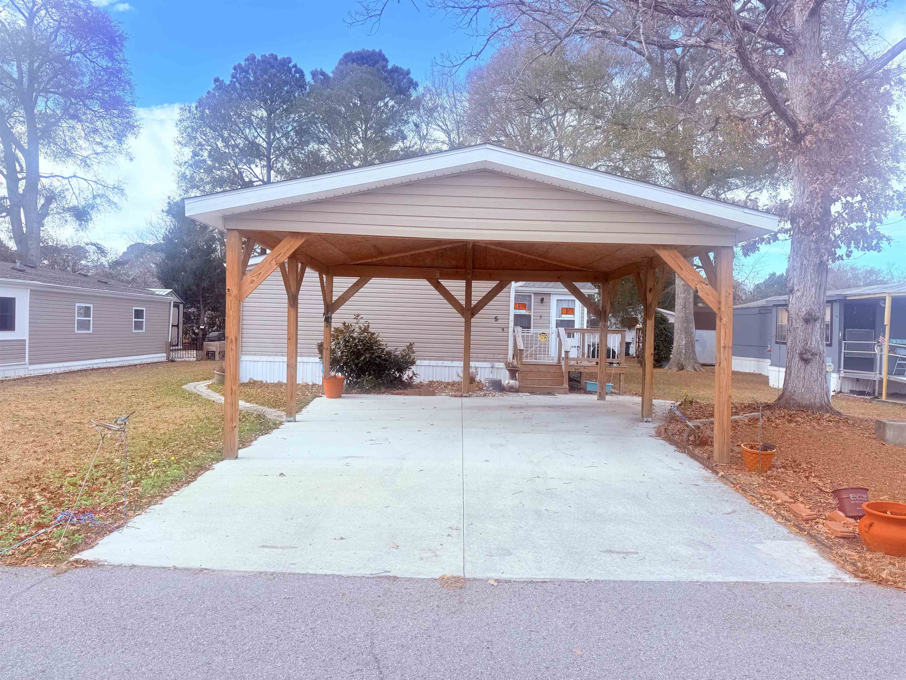 View of car parking featuring a detached carport and driveway