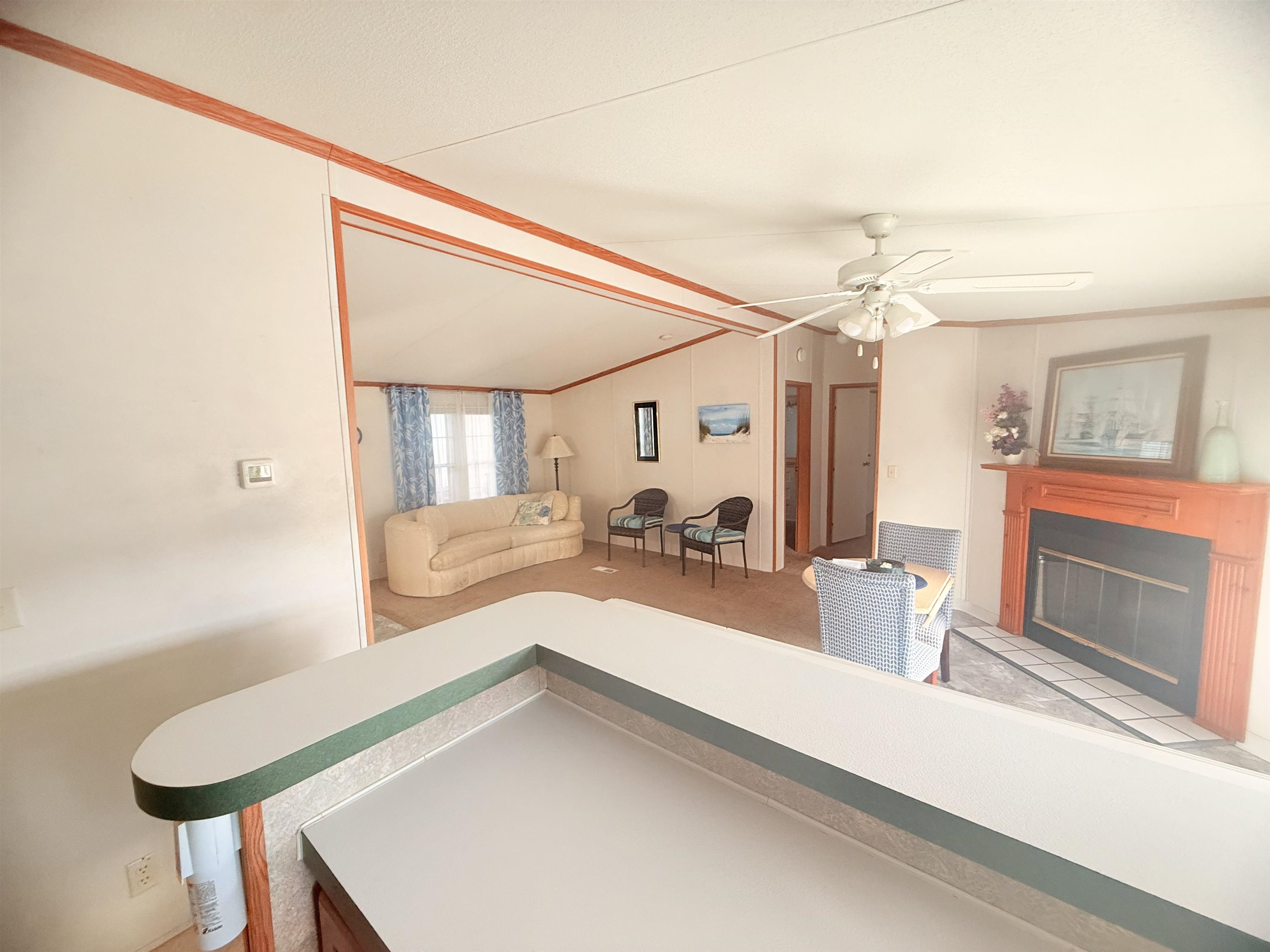 5 Buccaneer Street Murrells Inlet, SC 29576 - Photo 23 of 30 Living room with a glass covered fireplace, vaulted ceiling, a ceiling fan, and ornamental molding