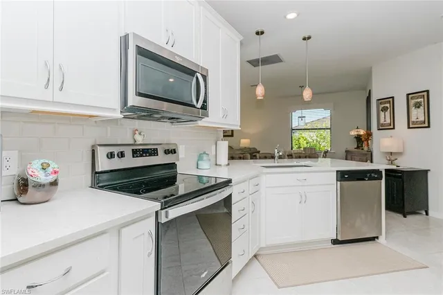 a kitchen with stainless steel appliances white cabinets and white appliances