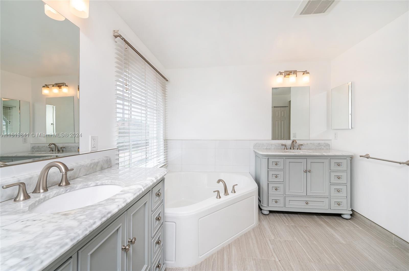 4136 Southwest 179th Way Miramar, FL 33029 - Photo 24 of 42 a bathroom with a granite countertop double vanity sink and mirror with bathtub