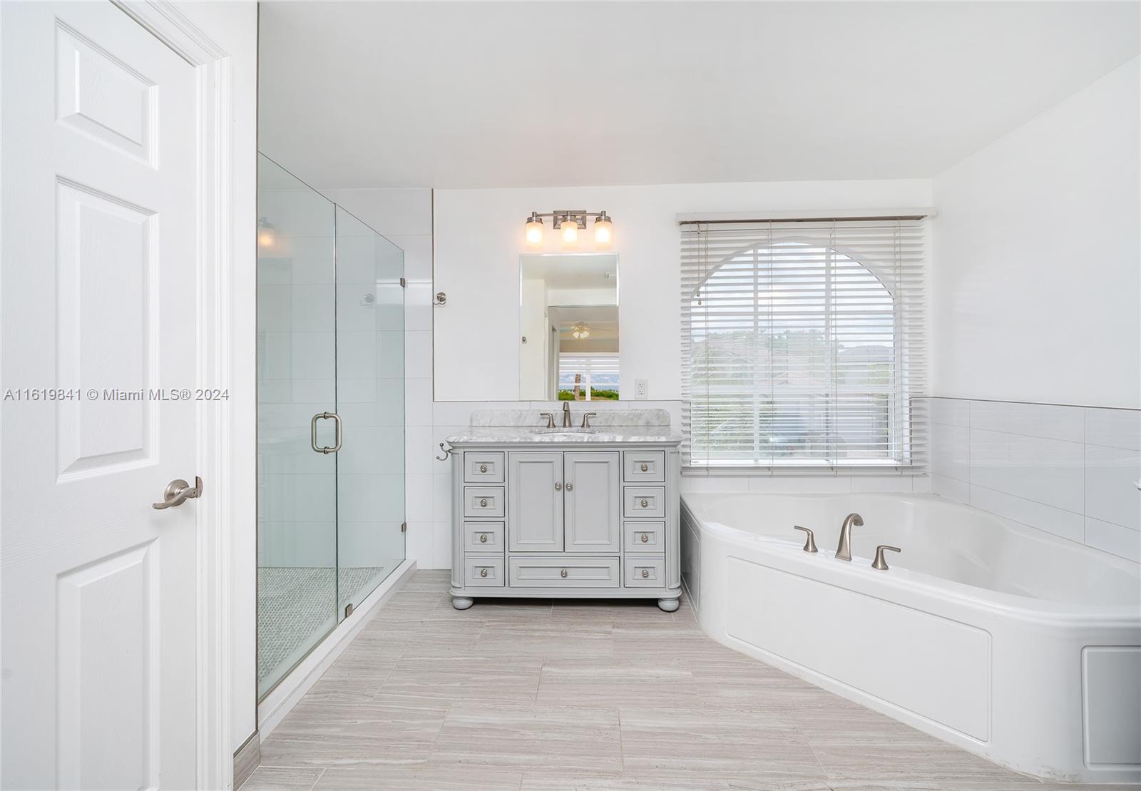 4136 Southwest 179th Way Miramar, FL 33029 - Photo 25 of 42 a bathroom with a tub a sink and a window