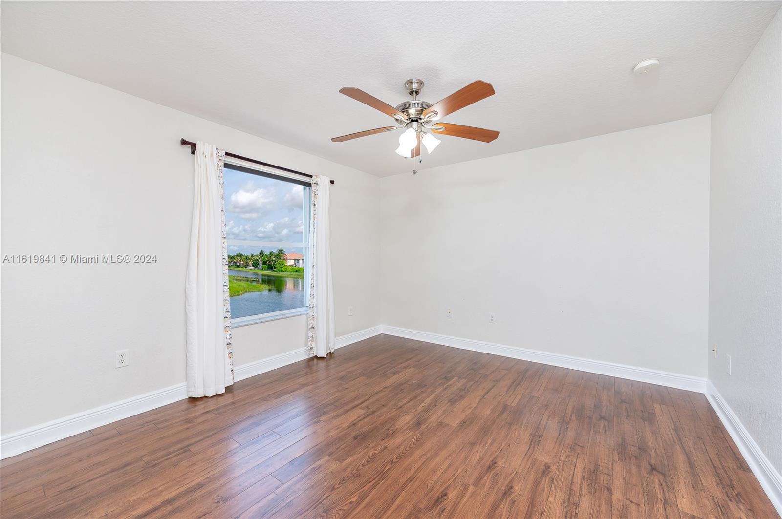 4136 Southwest 179th Way Miramar, FL 33029 - Photo 26 of 42 a view of an empty room with wooden floor and a window